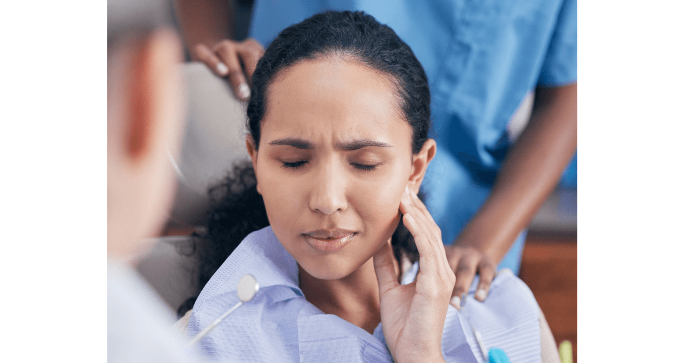 Patient holding jaw in pain, showing dry socket symptoms after wisdom tooth removal in Cardiff