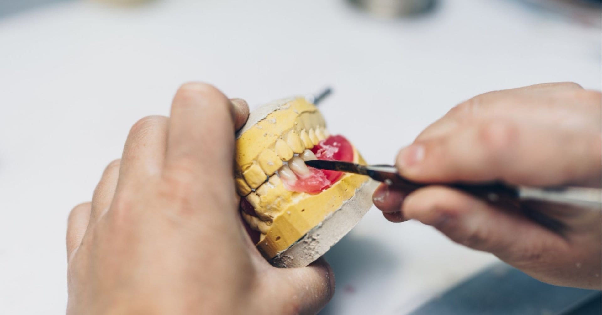 dental technician working on a denture mounted on a cast in Cardiff